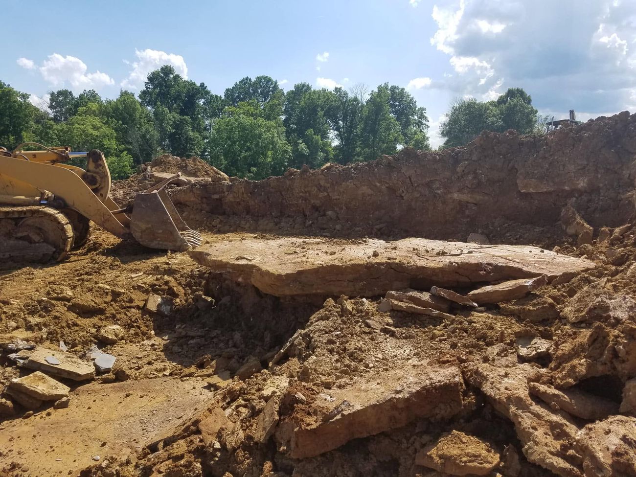 A large excavation cut into a site with a dozer working