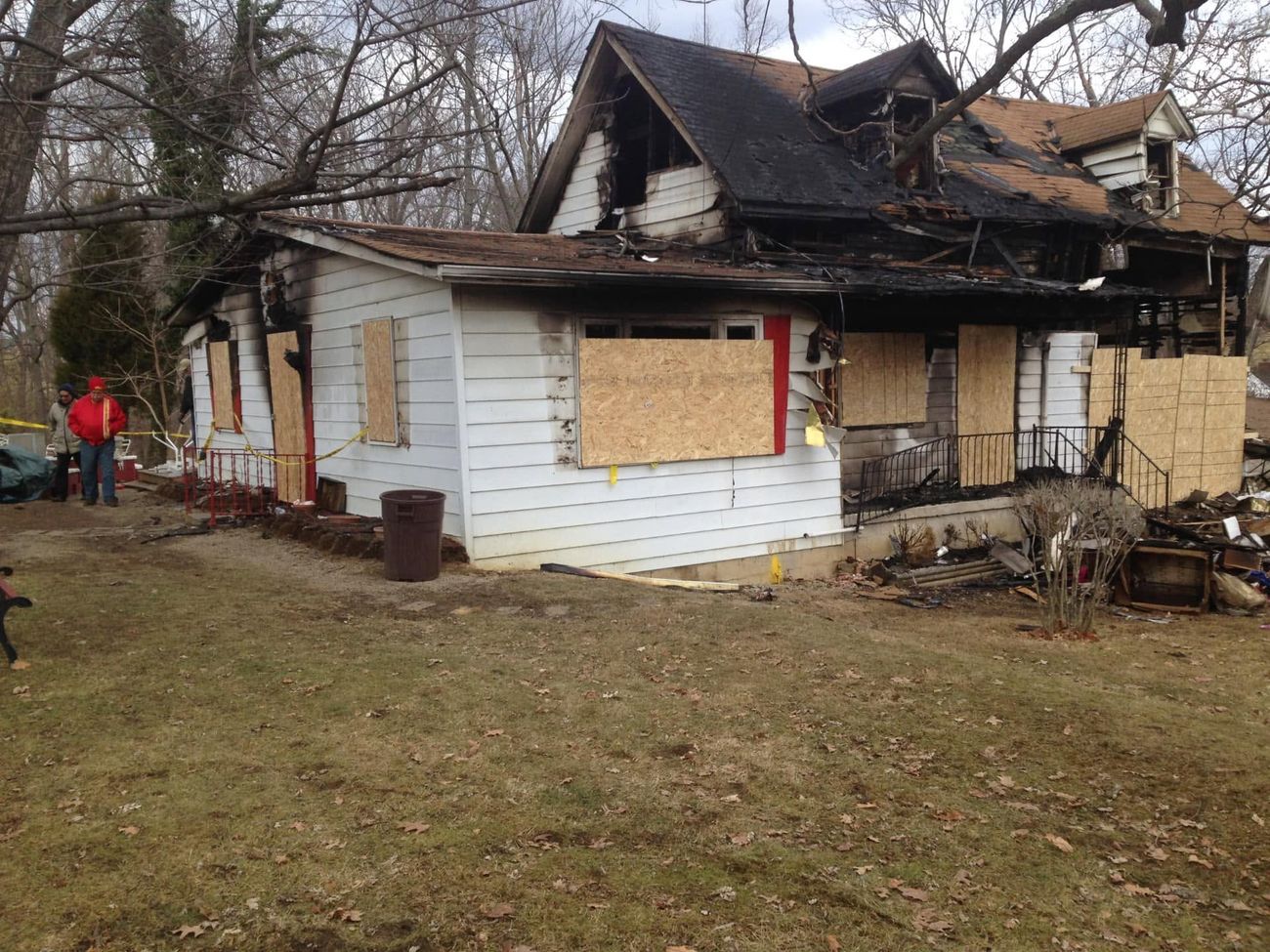 A fire-damaged house secured before demolition